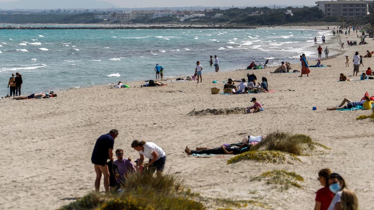 Menschen am Strand von Mallorca: Die Auflagen auf der beliebten Urlaubsinsel sind strenger als in Deutschland.