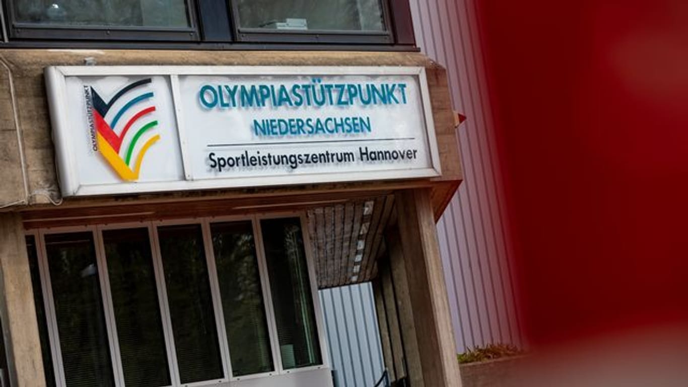 Ein Banner hängt über dem Haupteingang des Olympiastützpunktes Niedersachsen: Dort ist es zu einem Corona-Ausbruch unter den Sportlern gekommen.