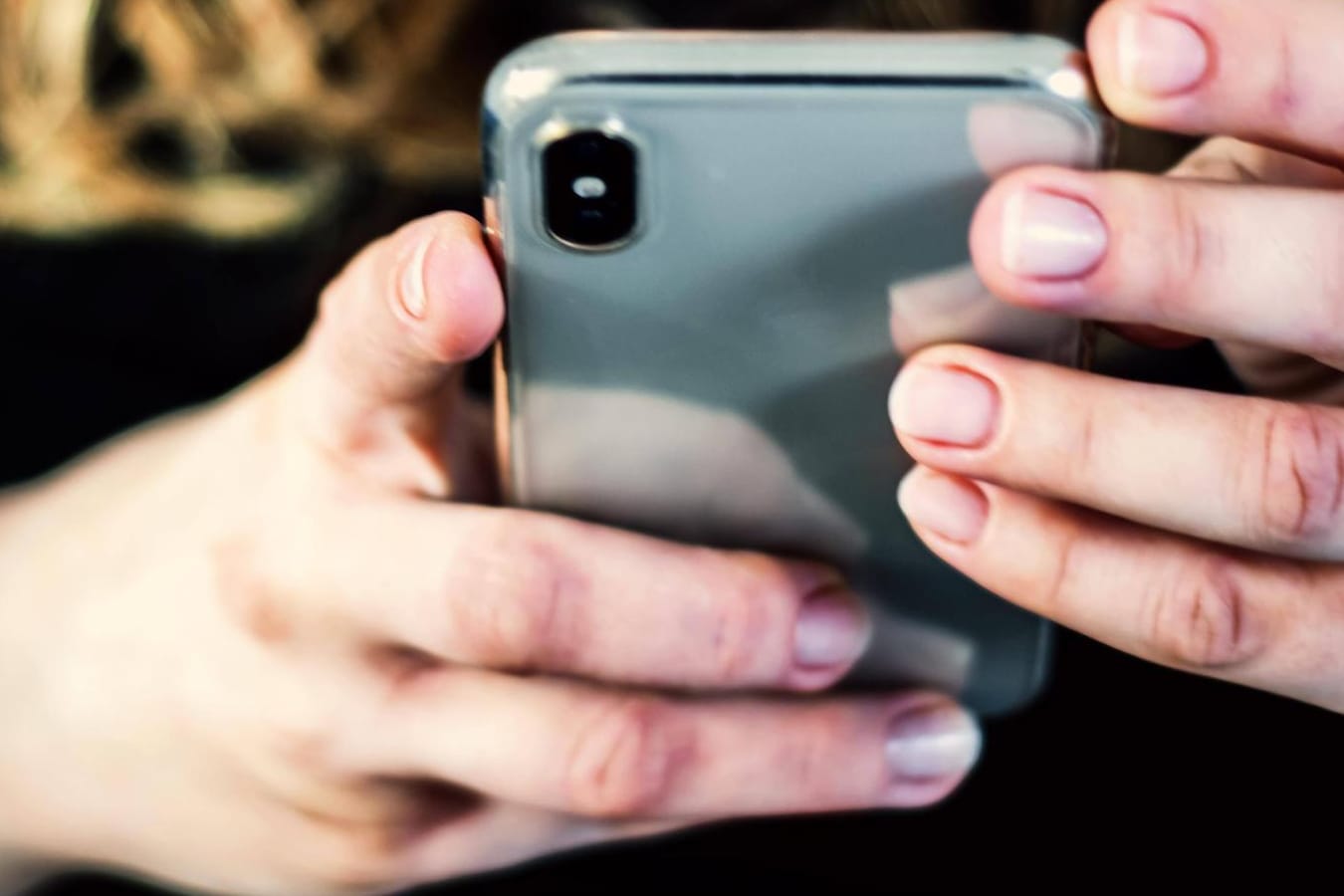 Eine Frau tippt auf einem Smartphone (Symbolbild): Nach einem Daten-Leak bei Facebook berichten einige Twitter-Nutzer über Spam-SMS.