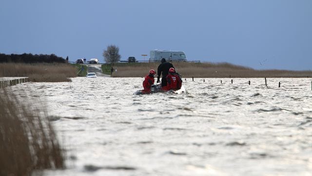Rettungskräfte im Meer vor Ostfriesland, die von der Flut überraschten Ausflüglern helfen.