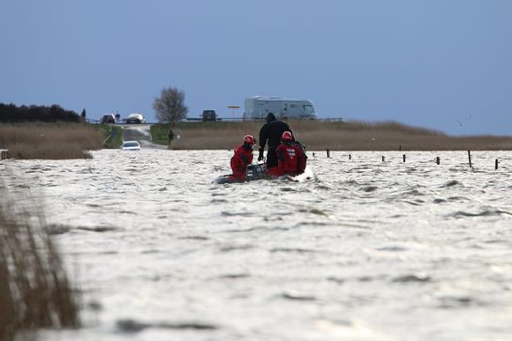 Rettungskräfte im Meer vor Ostfriesland, die von der Flut überraschten Ausflüglern helfen.
