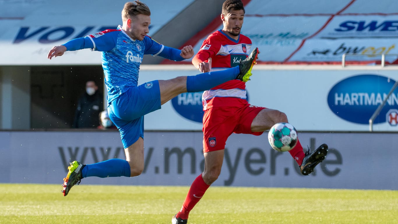 Hoch das Bein: Heidenheims Torschütze Tim Kleindienst (r.) und der Kieler Jannik Dehm streiten über Hüfthöhe um den Ball.