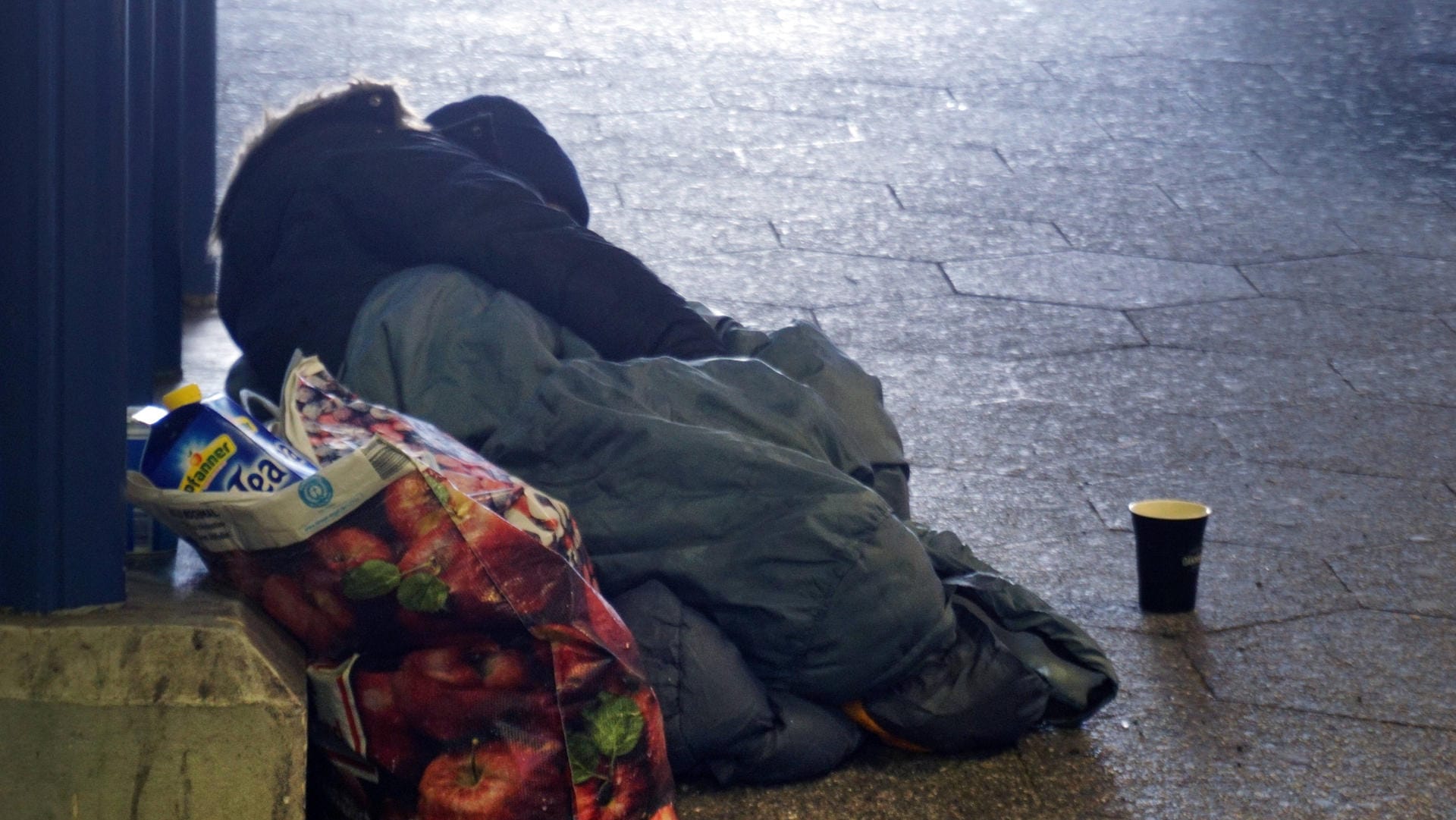 Eine von Obdachlosigkeit betroffene Person schläft auf dem Boden (Symbolbild): In Mainz wurde einem Obdachloser 50 Euro Strafe verschrieben, weil er gegen die Ausgangssperre verstoßen hat.