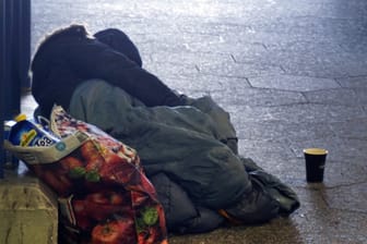 Eine von Obdachlosigkeit betroffene Person schläft auf dem Boden (Symbolbild): In Mainz wurde einem Obdachloser 50 Euro Strafe verschrieben, weil er gegen die Ausgangssperre verstoßen hat.