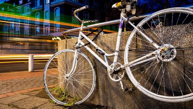 Fahrzeuge fahren an einem sogenannten "Ghost Bike" vorbei, welches an einer Kreuzung in Hannover an einen tödlich verunglückten Fahrradfahrer erinnert. Fahrzeuge fahren an einem sogenannten "Ghost Bike" vorbei, welches an einer Kreuzung in Hannover an einen tödlich verunglückten Fahrradfahrer erinnert.