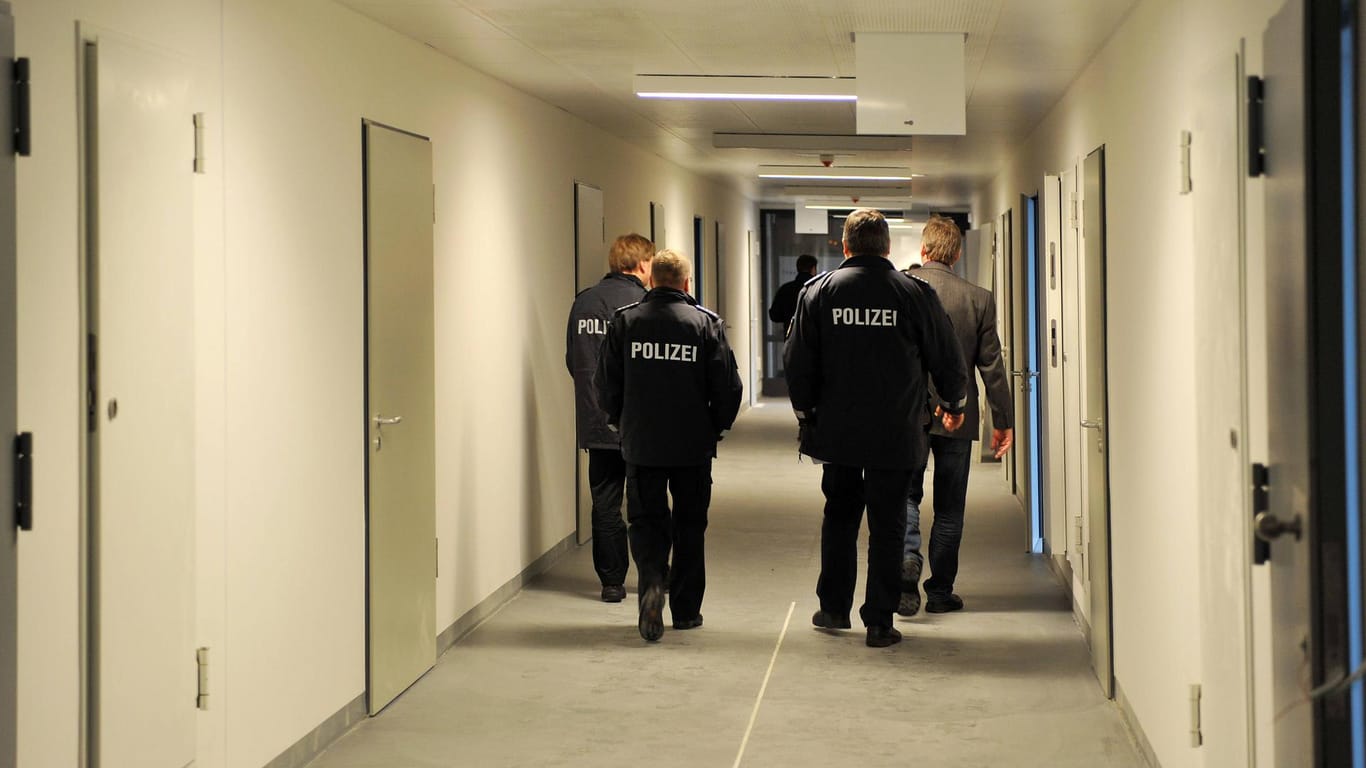 Polizeibeamte gehen durch einen Flur in der Justizvollzugsanstalt in Bremen (Archivbild): Nach einer Attacke auf einen Mitarbeiter musste dieser operiert werden.