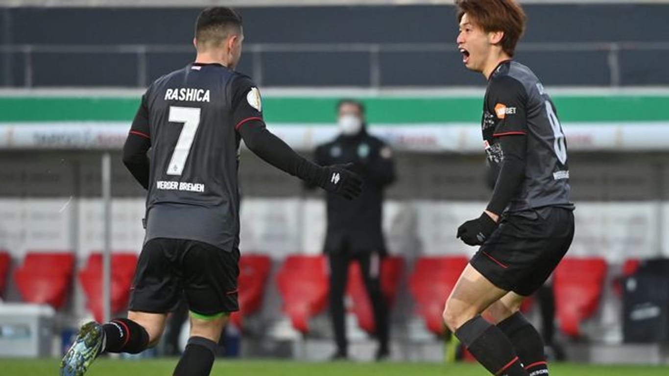 Bremens Torschütze Yuya Osako feiert mit Milot Rashica (l) das Tor zum 1:0 gegen Jahn Regensburg.