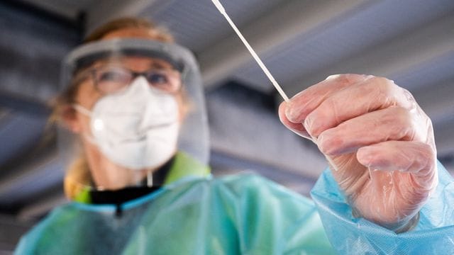 Eine Helferin hält einen Corona-Teststab im "Testzentrum am Zoo" in Hannover in der Hand. Eine Helferin hält einen Corona-Teststab im "Testzentrum am Zoo" in Hannover in der Hand.
