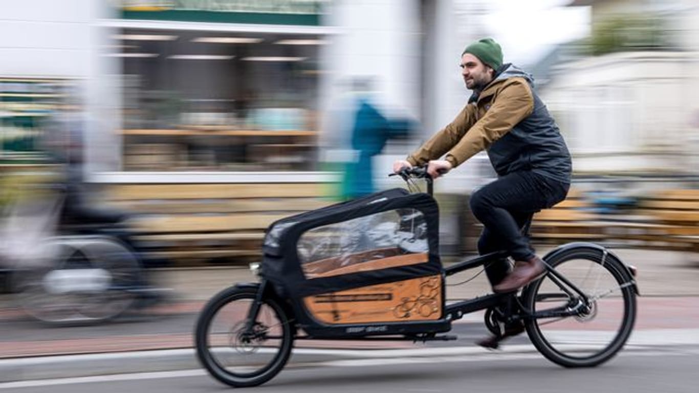 Ernst Schäfer, Mitbegründer des Lastenradverleihs "Rädchen für alles", fährt auf einem Lastenrad durch die Innenstadt.