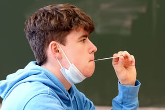 Schüler beim Corona-Test mit der Lolli-Methode (Symbolbild): Nach den Osterferien soll es die Testmöglichkeit für alle Kölner Schüler geben.