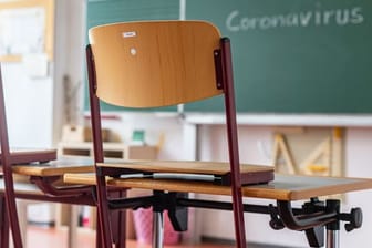 "Coronavirus" steht auf einer Tafel in einem leeren Klassenzimmer (Symbolbild): Viele Schulen kehren auch nach den Osterferien nicht zurück zum Präsenzunterricht.