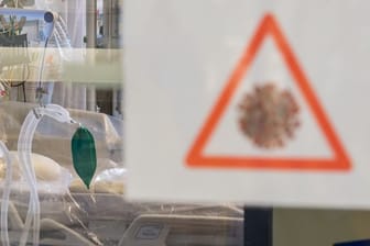 Ein Intensivbett mit Beatmungseinheit steht auf einer Corona-Station hinter einer Scheibe (Symbolbild): In Niedersachsen werden fast 300 Corona-Patienten auf Intensivstationen behandelt.