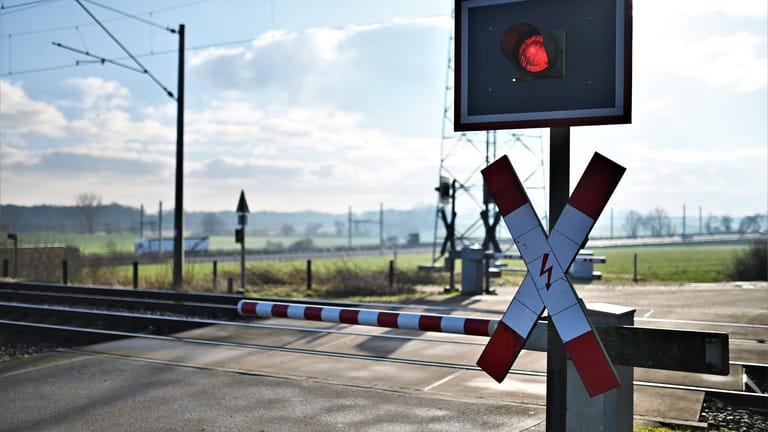 Ein Bahnübergang (Symbolbild): Weil sie sich auf einem Bahnübergang zwischen die Gleise gelegt hatten, haben zwei Männer den Bahnverkehr zwischen Lübeck und Hamburg lahmgelegt.