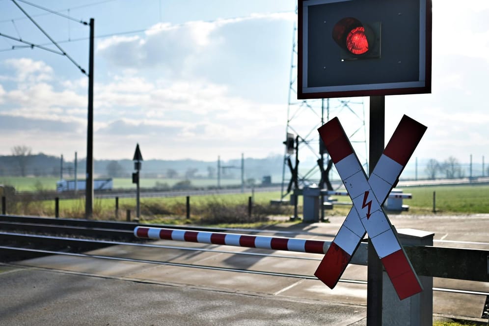 Ein Bahnübergang (Symbolbild): Weil sie sich auf einem Bahnübergang zwischen die Gleise gelegt hatten, haben zwei Männer den Bahnverkehr zwischen Lübeck und Hamburg lahmgelegt.