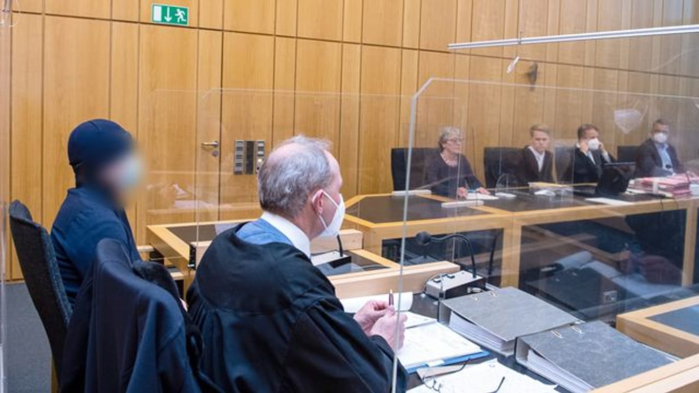 Der Angeklagte (l) sitzt im Landgericht Münster neben seinem Rechtsanwalt.