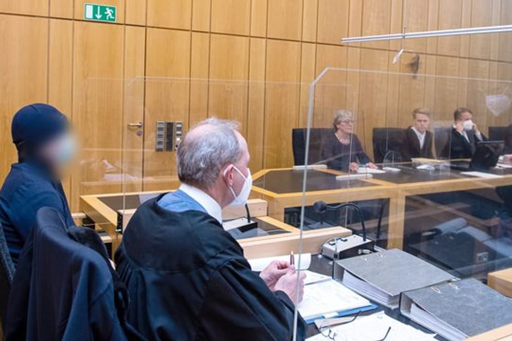 Der Angeklagte (l) sitzt im Landgericht Münster neben seinem Rechtsanwalt.