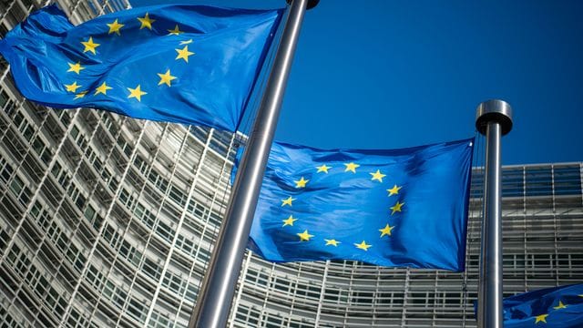 Flaggen der Europäischen Union wehen im Wind vor dem Berlaymont-Gebäude, dem Sitz der Europäischen Kommission. Flaggen der Europäischen Union wehen im Wind vor dem Berlaymont-Gebäude, dem Sitz der Europäischen Kommission.