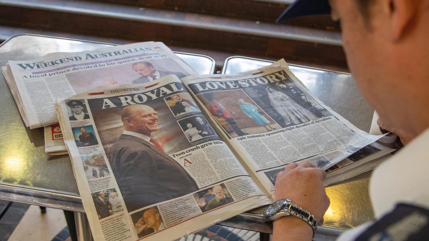Australien, Sydney: Yong Chen liest einen Artikel zum Tod von Prinz Philip in einem Café in Sydney.
