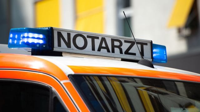 Ein Notarztwagen steht mit Blaulicht an einem Unfallort: Ein Streit zwischen Autofahrern eskalierte. Ein Notarztwagen steht mit Blaulicht an einem Unfallort: Ein Streit zwischen Autofahrern eskalierte.