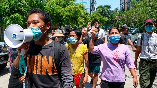 Menschen zeigen bei einer Demonstration in Yangon den Drei-Finger-Gruß als Zeichen des Widerstands. Menschen zeigen bei einer Demonstration in Yangon den Drei-Finger-Gruß als Zeichen des Widerstands.