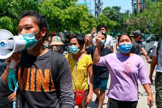 Menschen zeigen bei einer Demonstration in Yangon den Drei-Finger-Gruß als Zeichen des Widerstands.