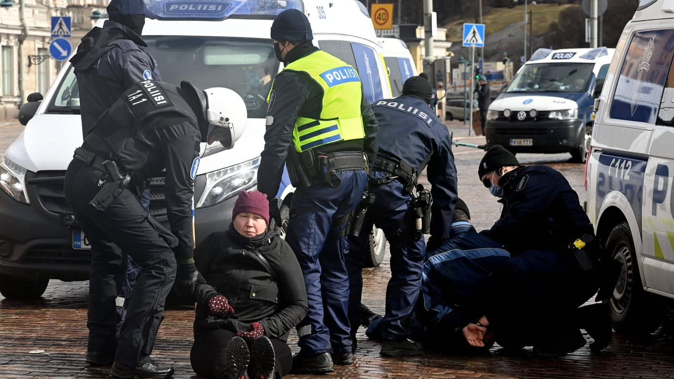 Polizisten nehmen Demonstranten in der finnischen Hauptstadt Helsinki fest. Der Protest war nicht genehmigt.