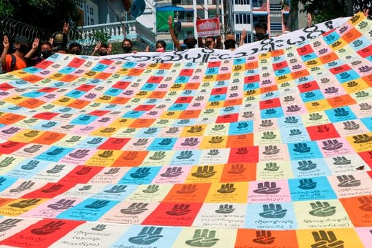 Zeichen des Widerstands: ein Transparent mit dem symbolischen Drei-Finger-Gruß.