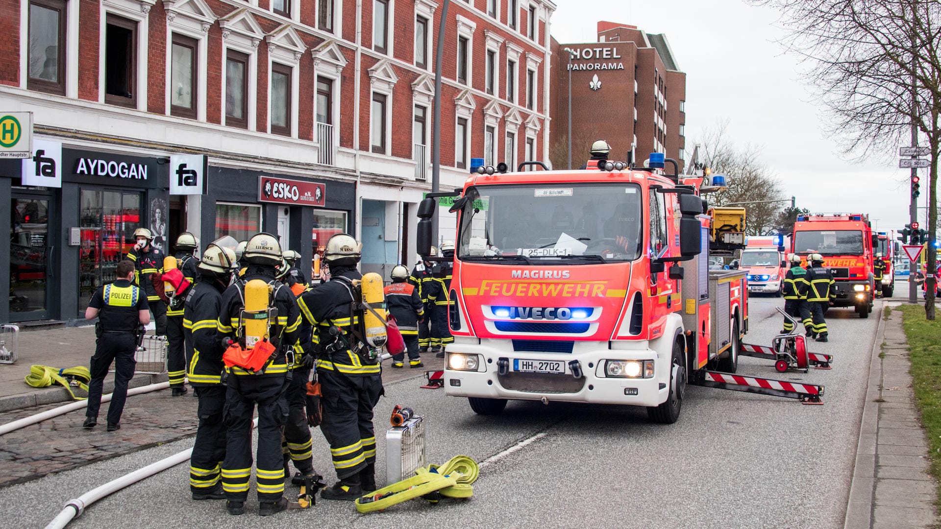 Hamburg: Feuerwehrleute stehen im Stadtteil Billstedt vor einer brennenden Wohnung. Bei dem Brand sind mehrere Menschen verletzt worden. Hamburg: Feuerwehrleute stehen im Stadtteil Billstedt vor einer brennenden Wohnung. Bei dem Brand sind mehrere Menschen verletzt worden.