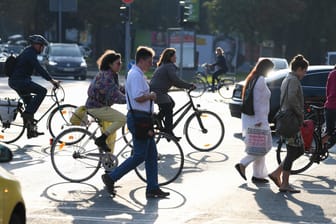 Radfahrer und Fußgänger überqueren eine Straßenkreuzung in Frankfurt (Archivbild): Um für sie mehr Platz und Sicherheit zu erreichen, bereiten Initiativen und Verbände ein hessenweites Volksbegehren über ein Verkehrswendegesetz vor.