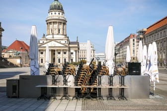 Gestapelte Stühle am Berliner Gendarmenmarkt: Die Gastronomie bleibt geschlossen, für die Abholung von Bestelltem gilt mit der Notbremse die Ausgangssperre.