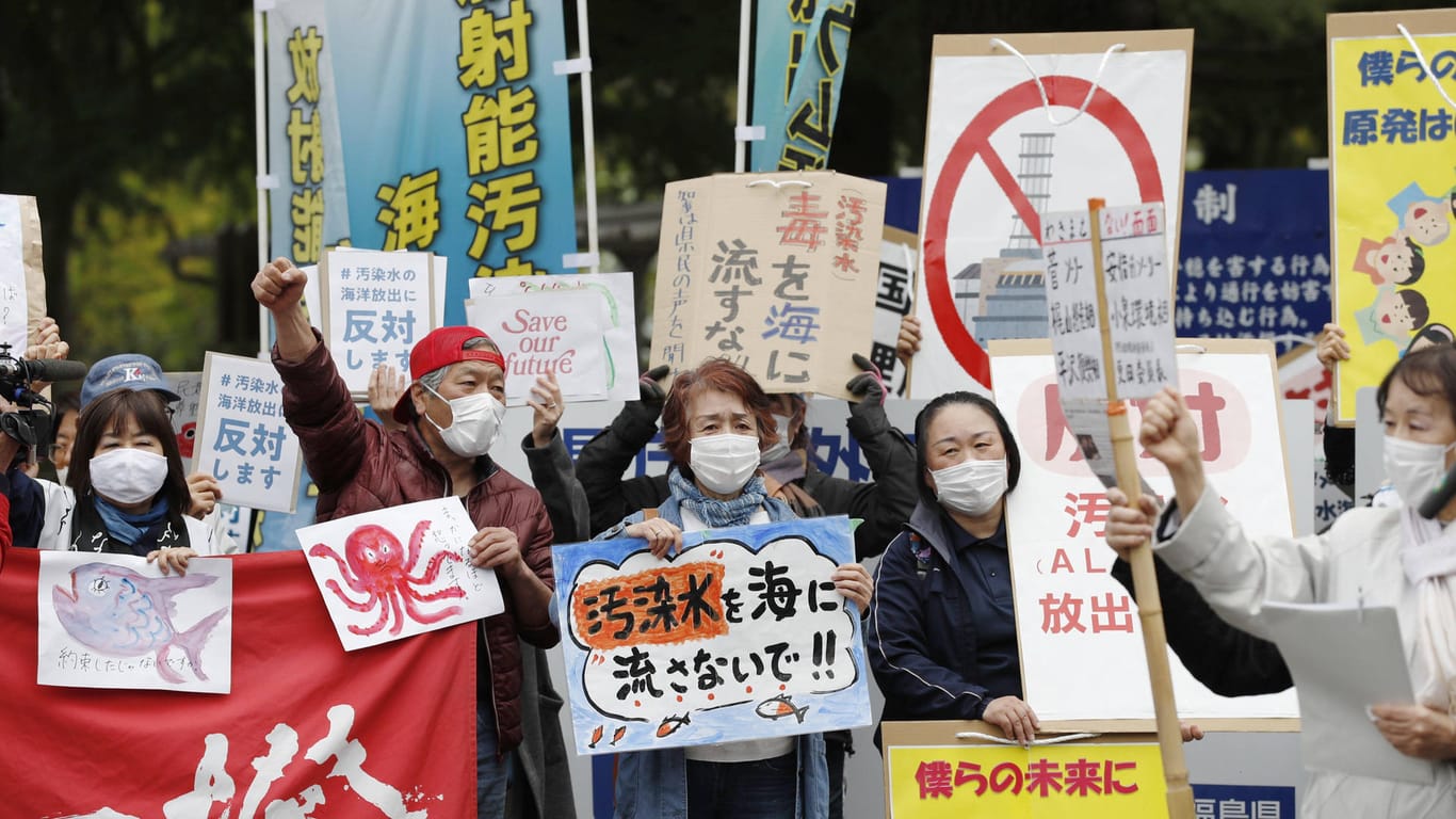 Menschen protestieren mit Schildern: Die Empörung in der Bevölkerung Japans ist groß.