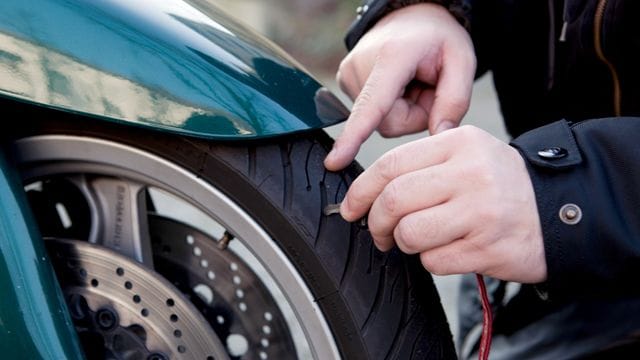 Prüfender Blick: Vor dem Start in die neue Motorradsaison schauen sich Biker die Reifen an ihrer Maschine besser genau an, um Beschädigungen und zu wenig Profiltiefe auszuschließen. Prüfender Blick: Vor dem Start in die neue Motorradsaison schauen sich Biker die Reifen an ihrer Maschine besser genau an, um Beschädigungen und zu wenig Profiltiefe auszuschließen.