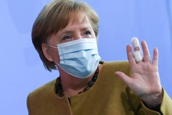 Kanzlerin Merkel bei ihrem Statement zur Corona-Krise: Der linke Mittelfinger ist bandagiert.