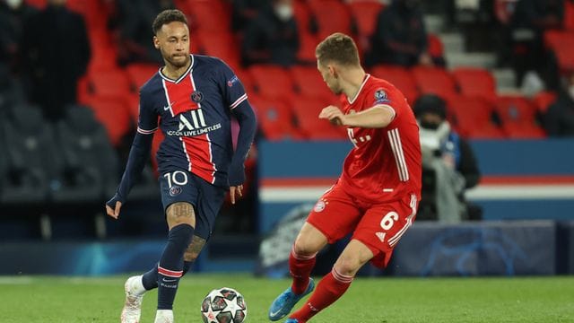 Neymar von Paris Saint-Germain (l) und Joshua Kimmich vom FC Bayern München kämpfen um den Ball.