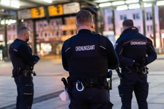 Drei Mitarbeiter des Ordnungsamts stehen auf dem Hagener Bahnhofsvorplatz (Symbolbild): In der Stadt gilt eine Ausgangssperre von 21 bis 5 Uhr.