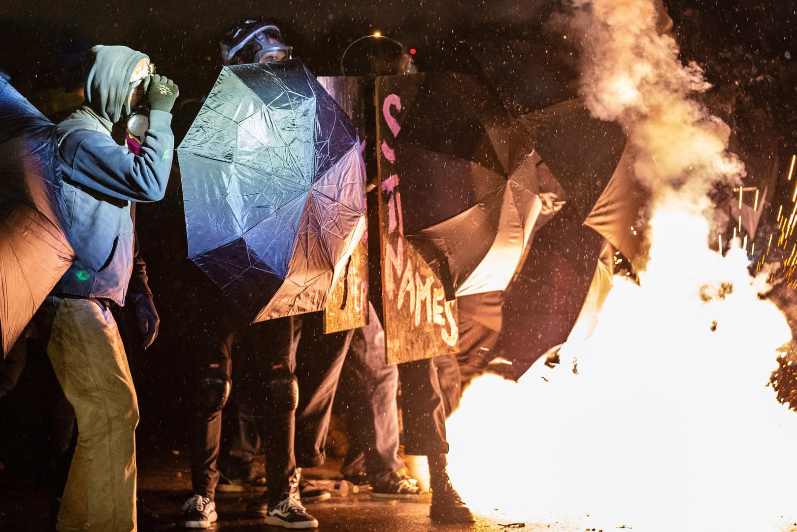 Demonstranten schützen sich vor dem Versuchen der Polizei, die Menge zu zerstreuen: In der Nacht kam es in Brooklyn Center wieder zu Ausschreitungen.