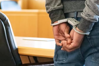 Eine Person ist mit Handschellen gefesselt (Symbolbild): Nach einem Hinweis hat die Polizei die Ermittlungen gegen einen 21-jährigen Wuppertaler gestartet.