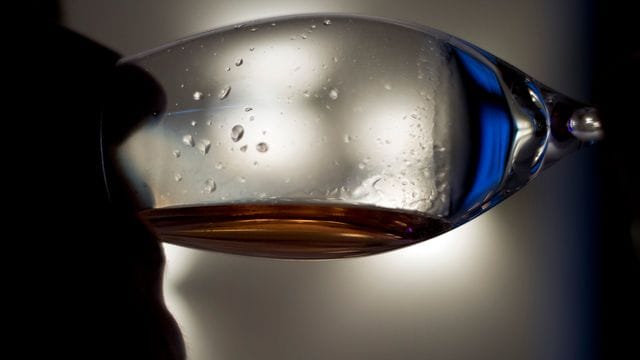Eine Frau trinkt ein Glas Wein.