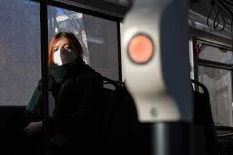 Eine Frau sitzt mit Mund-Nasen-Schutz in einem Bus (Symbolbild): Wissenschaftler der Uni Leipzig untersuchten die Entwicklung der Suizidrate im ersten Corona-Lockdown.