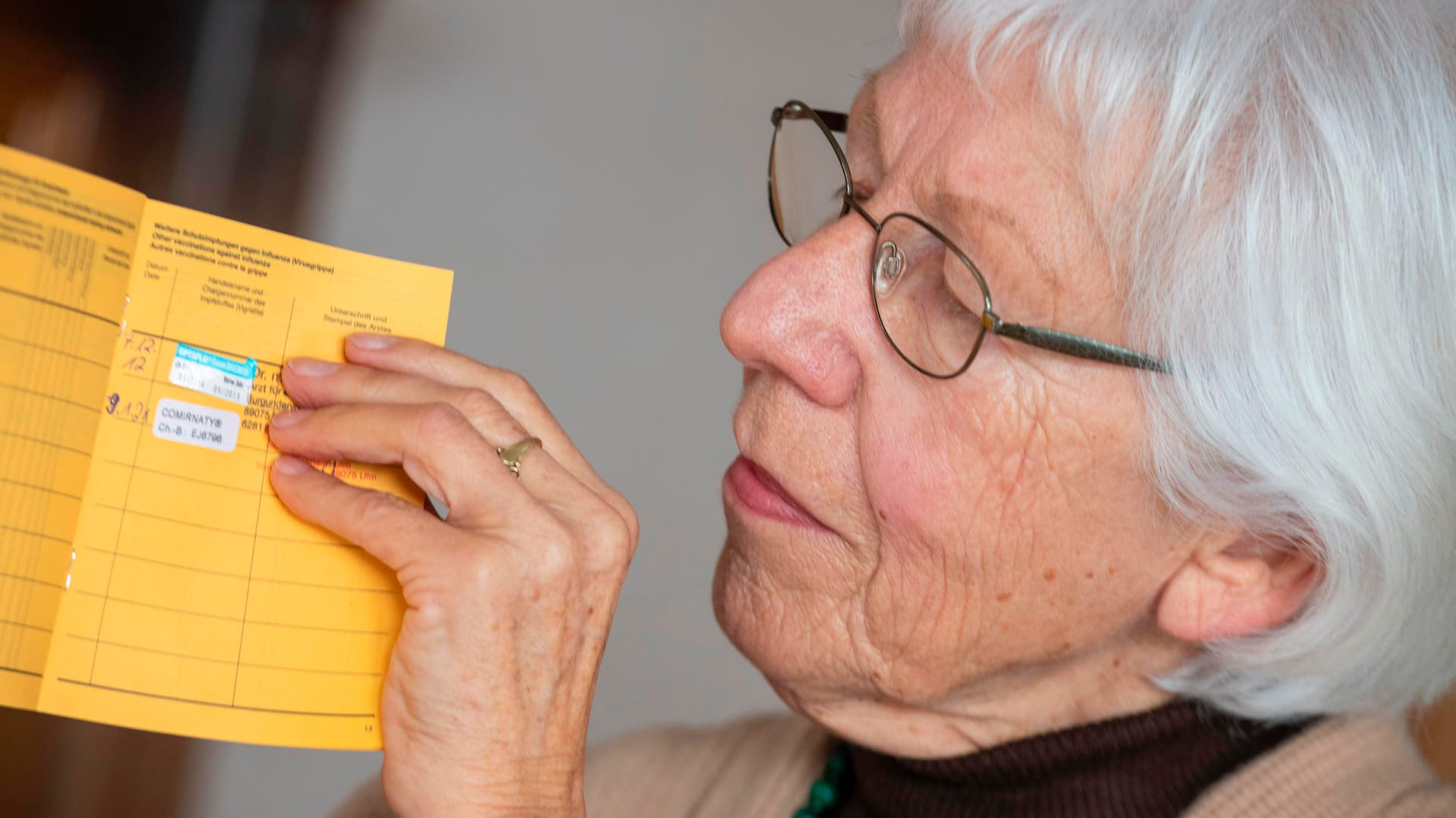 Eine Seniorin hält ihren Impfpass, in dem eine Grippe-Impfung und die erste Corona-Impfung vermerkt sind: Im Sommer soll der digitale Impfpass kommen.