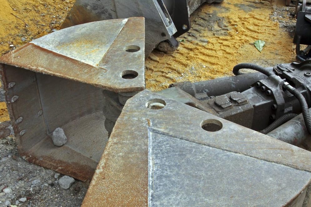 Baggerschaufeln liegen vor einem Sandhaufen (Symbolbild): Vier Baggerschaufeln und ein Kabel wurden von einem Lagerplatz geklaut.