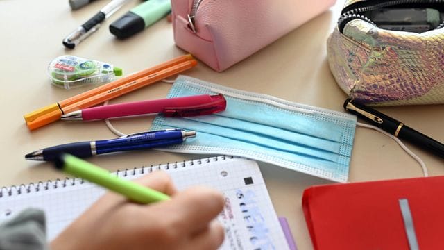 Ein Mund-Nasen-Schutz liegt auf dem Tisch einer Schülerin (Symbolbild): Nach einer Woche Distanzunterricht sollen die Schüler in NRW wieder in den Wechselunterricht zurückkehren.