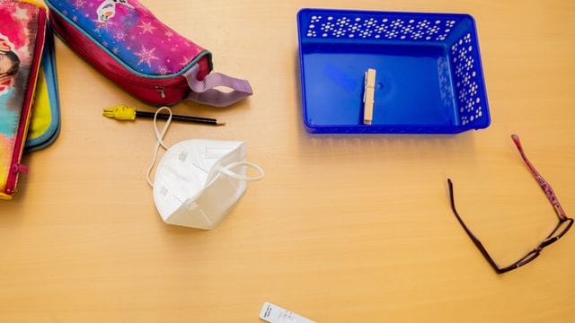 Ein Schnelltest, eine FFP2-Maske sowie andere Utensilien liegen bei einem Probelauf mit Corona-Schnelltests an der Grundschule in der Köllnischen Heide in Berlin-Neukölln auf einem Schultisch. Ein Schnelltest, eine FFP2-Maske sowie andere Utensilien liegen bei einem Probelauf mit Corona-Schnelltests an der Grundschule in der Köllnischen Heide in Berlin-Neukölln auf einem Schultisch.