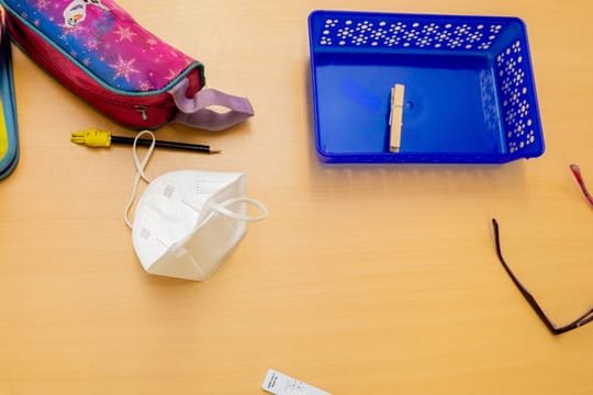 Ein Schnelltest, eine FFP2-Maske sowie andere Utensilien liegen bei einem Probelauf mit Corona-Schnelltests an der Grundschule in der Köllnischen Heide in Berlin-Neukölln auf einem Schultisch.