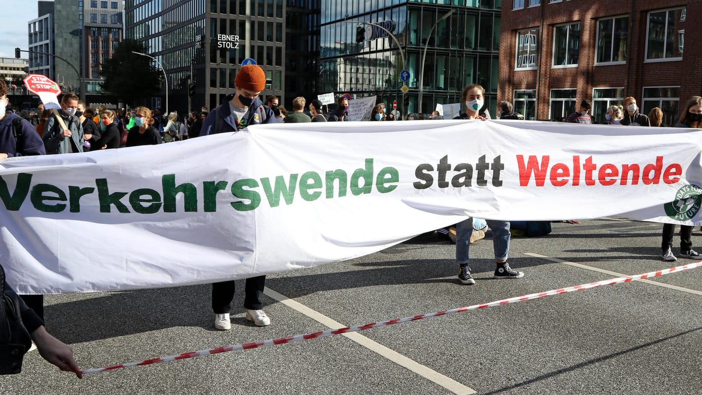 Demonstrierende halten ein Banner vor sich (Archivbild): Bei Protesten haben sich Aktivisten auf verschiedenen Autobahnen bei Bremen von Brücken abgeseilt.