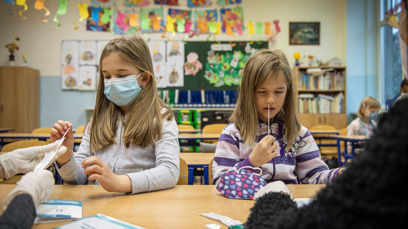 Zwei Mädchen machen einen Corona-Selbsttest in der Schule (Symbolbild): Seitdem die flächendeckenden Tests in Hamburger Schulen durchgeführt werden, wurden vergleichsweise wenige Infektionen mit dem Virus nachgewiesen.