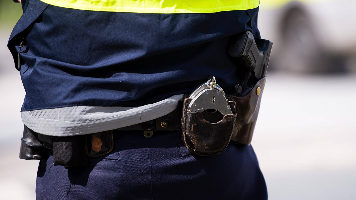 Handschellen hängen am Gürtel eines Polizisten (Symbolbild): Weil sich der Mann nicht beruhigen ließ, musste er fixiert werden.
