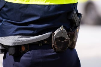 Handschellen hängen am Gürtel eines Polizisten (Symbolbild): Weil sich der Mann nicht beruhigen ließ, musste er fixiert werden.