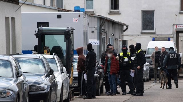 Einsatzkräfte der Polizei neben festgenommenen Personen: Acht von ihnen sitzen nun in Untersuchungshaft. Einsatzkräfte der Polizei neben festgenommenen Personen: Acht von ihnen sitzen nun in Untersuchungshaft.