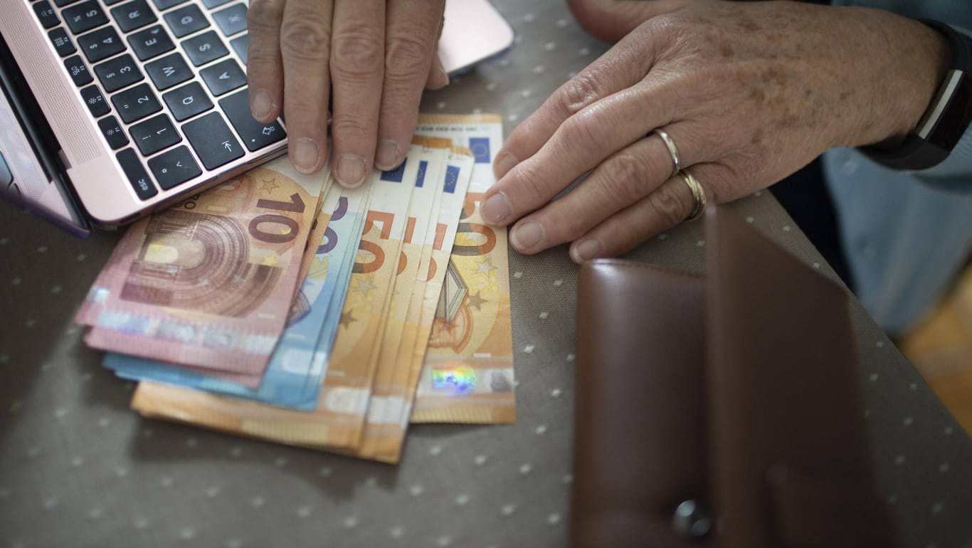 Eine ältere Frau mit Bargeld (Symbolbild): In Köln sind Senioren auf eine Betrugsmasche reingefallen.